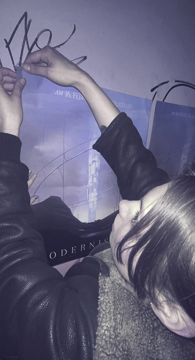 Modernismus 7 Berlin techno and live music underground club event poster design, concept art showing a glowing LED tower in a futuristic desert landscape, photo of Hannah Brückmann hanging the poster